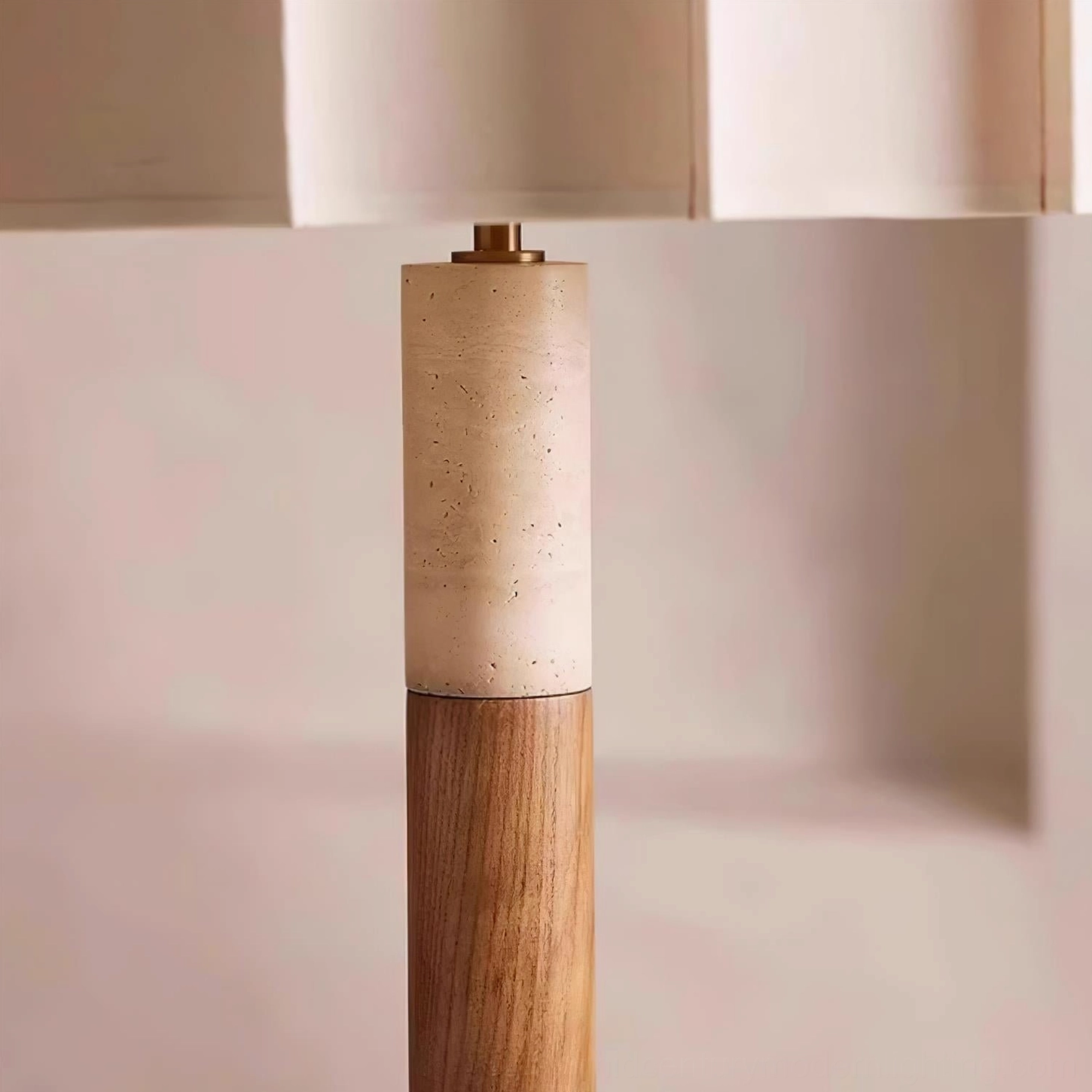Close-up detail of Calypso floor lamp pole joint showing travertine and solid walnut wood layering with brass hardware