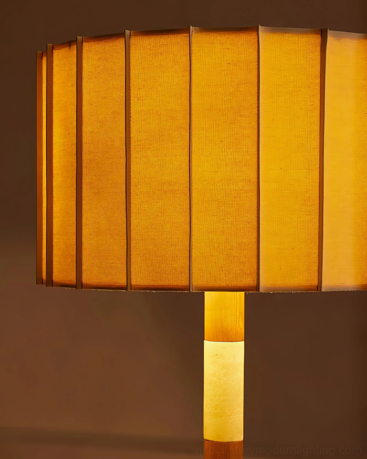 Calypso pleated fabric lampshade close-up with vertical pleats and warm amber ambient light glow