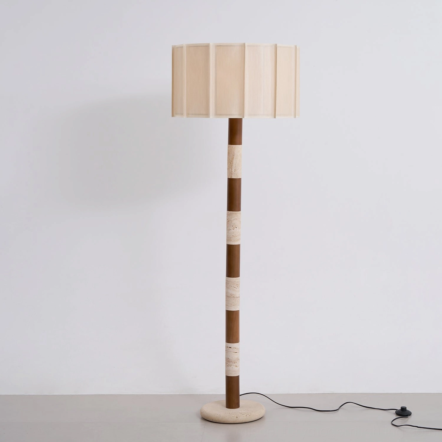 Calypso floor lamp positioned in corner reading nook with natural light, walnut wood travertine combination