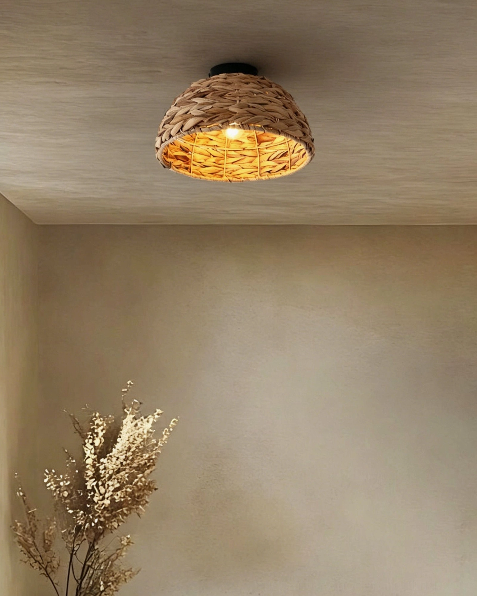 Cambria ceiling light front view lit bulb visible through woven hyacinth shade showing warm glow and texture detail