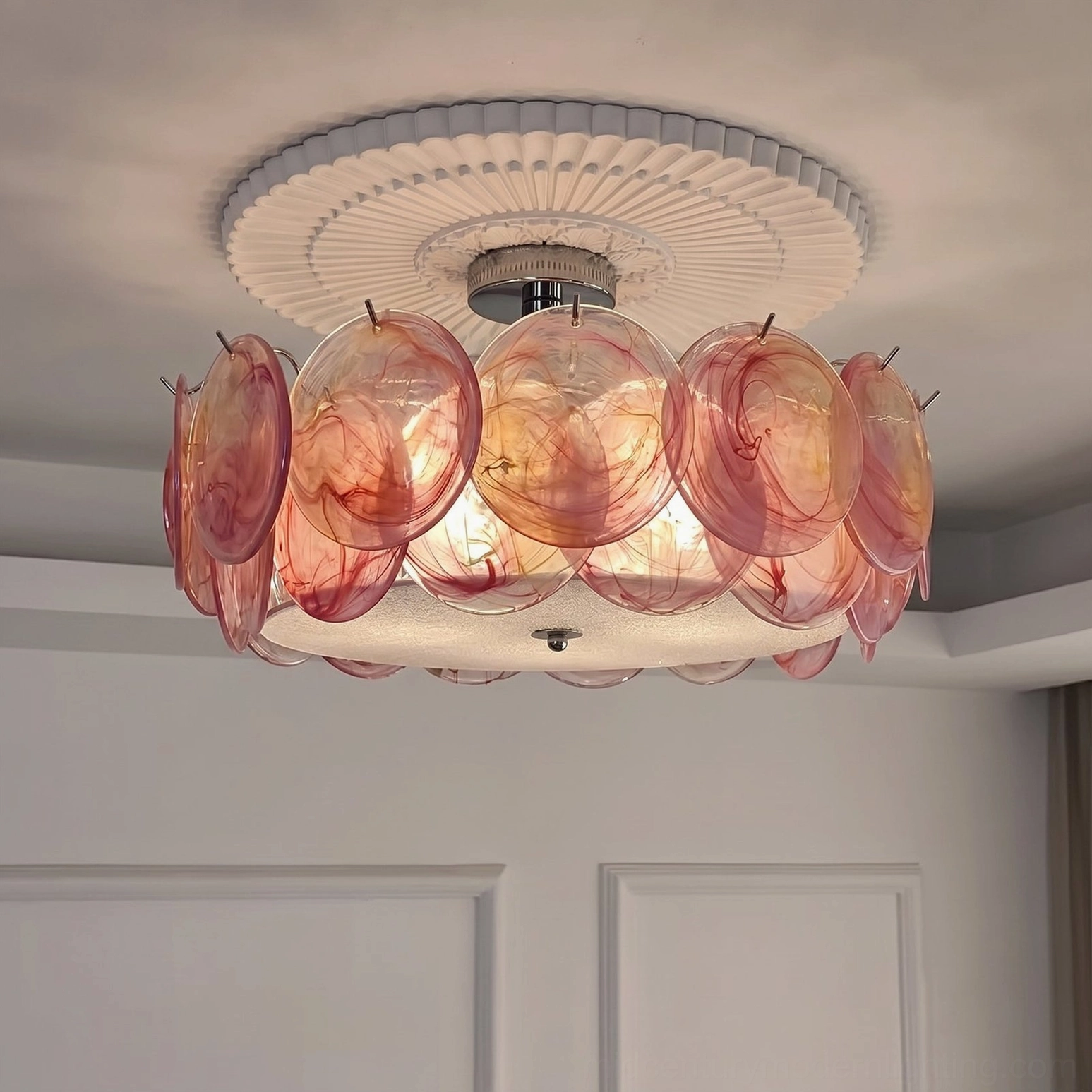 Pink glass flush mount ceiling light installed in bedroom with scalloped ceiling medallion, overhead view showing shadowless illumination