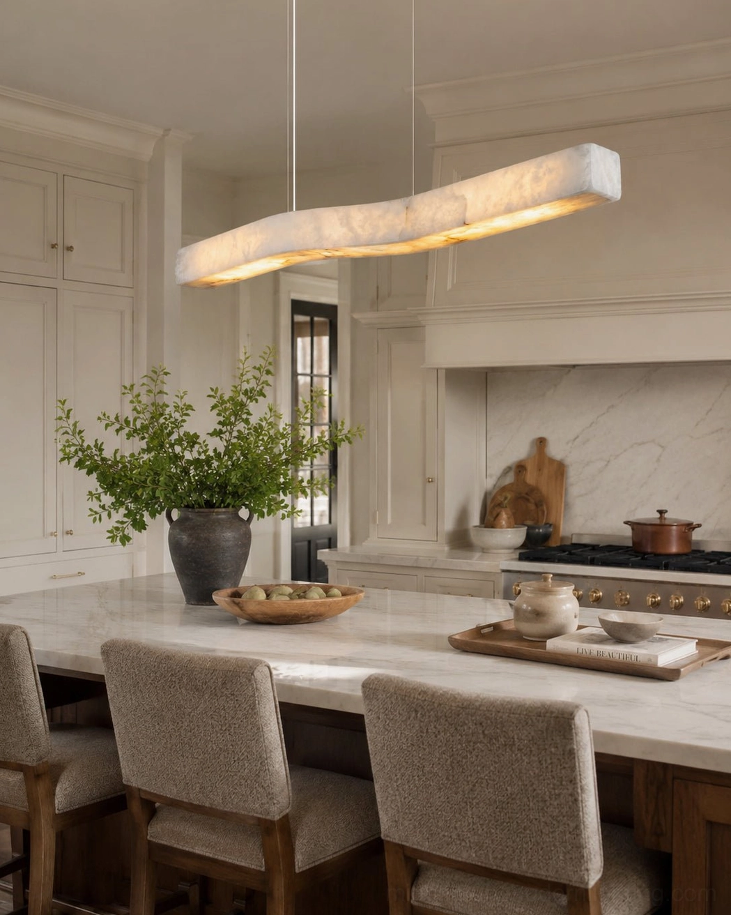 Camur alabaster chandelier hanging above farmhouse kitchen island with warm neutral tones and bright natural lighting