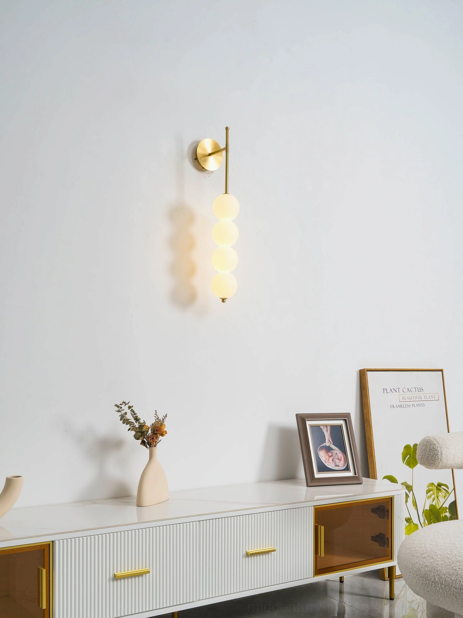 Candied Haws brass sconce with multiple frosted glass spheres creating geometric wall art installation