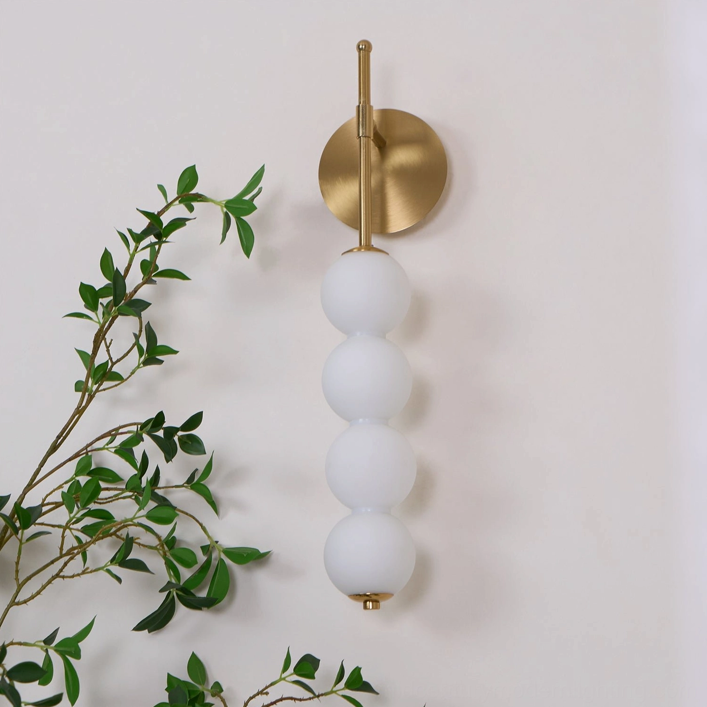 Candied Haws brass wall sconce with frosted glass globes in contemporary modern interior setting