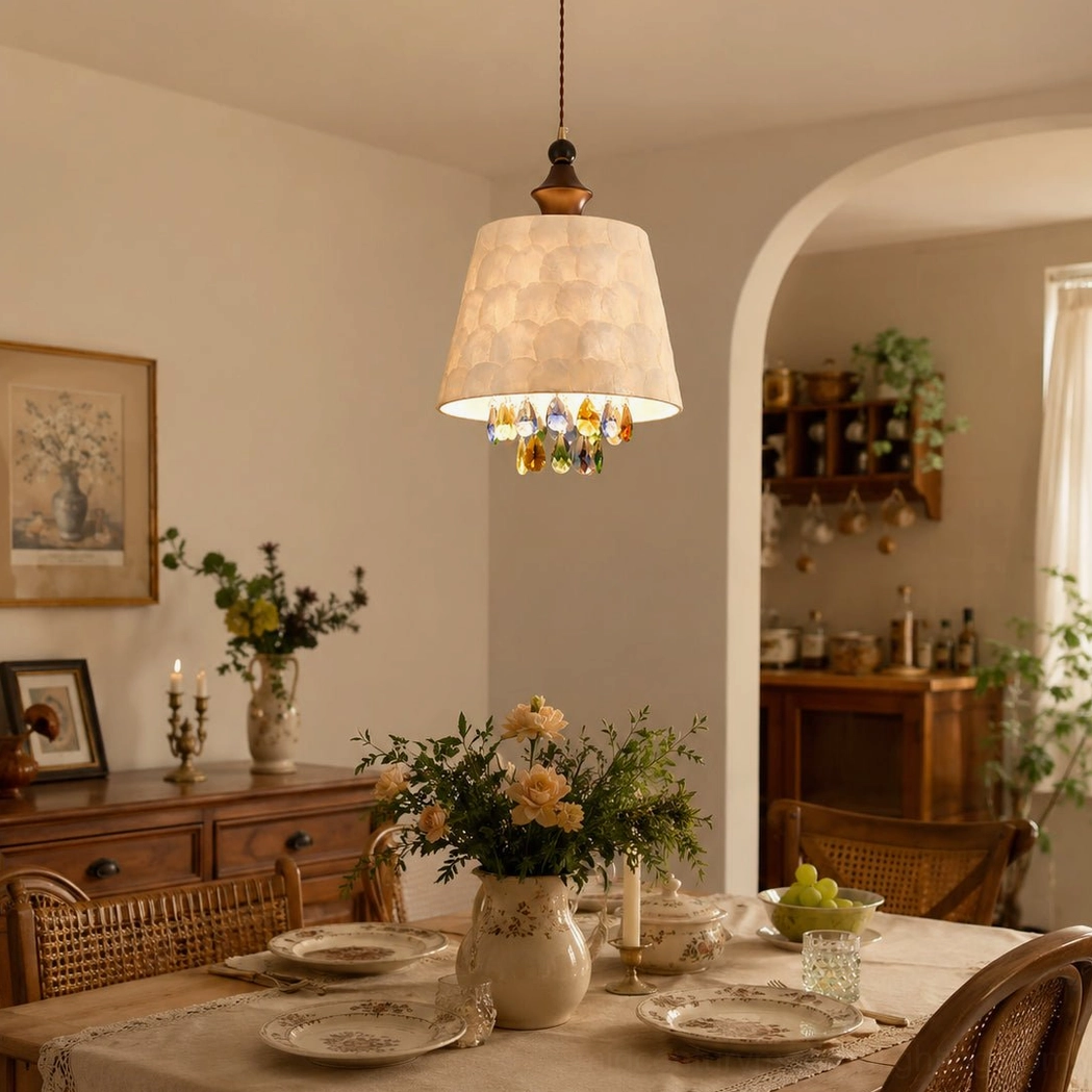 Capiz shell pendant light hanging in warm vintage dining room with beige shade, brass hardware, and traditional wooden furniture