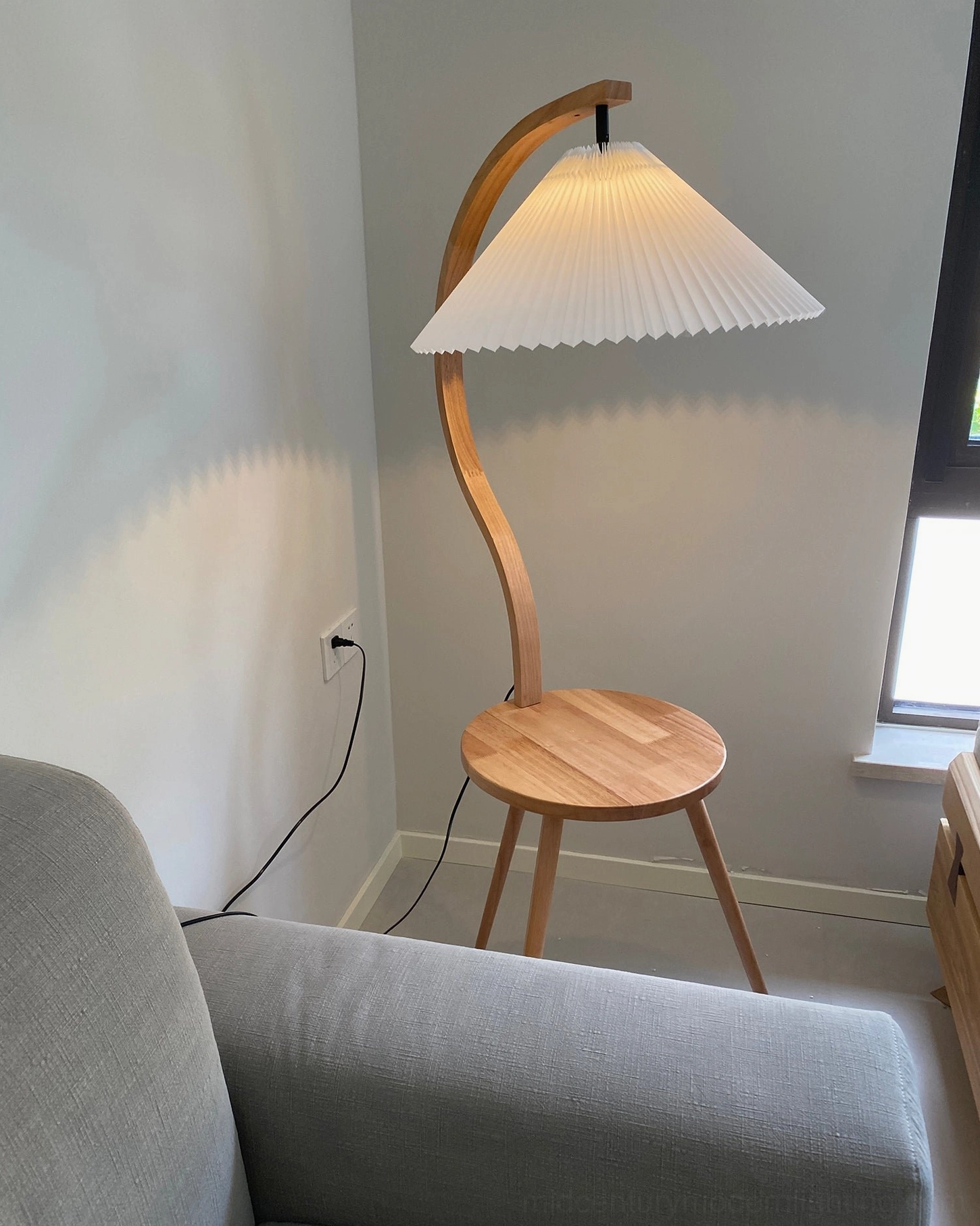 Caprani modern floor lamp creating ambient warmth in cozy residential interior corner
