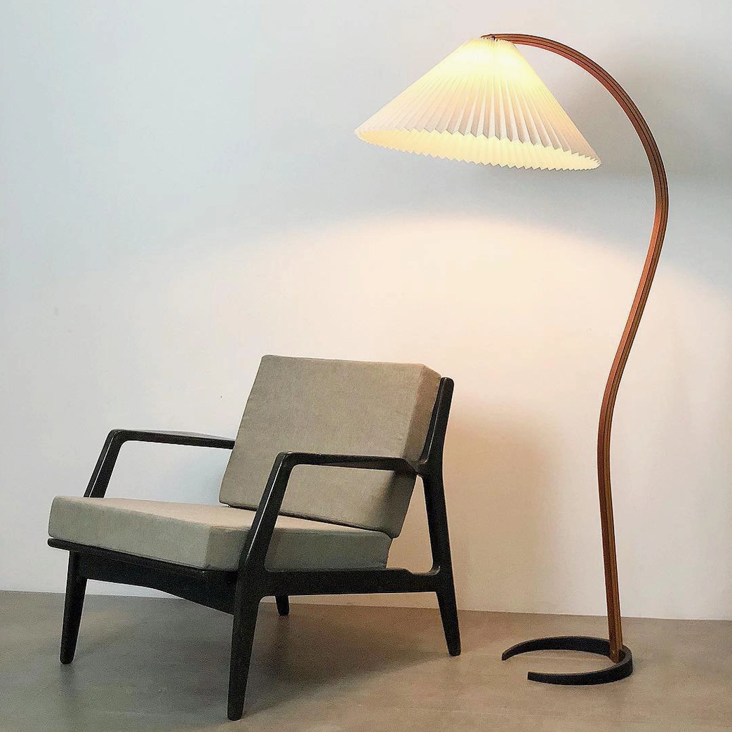 Caprani beige linen shade floor lamp warm lighting in mid-century modern interior setting