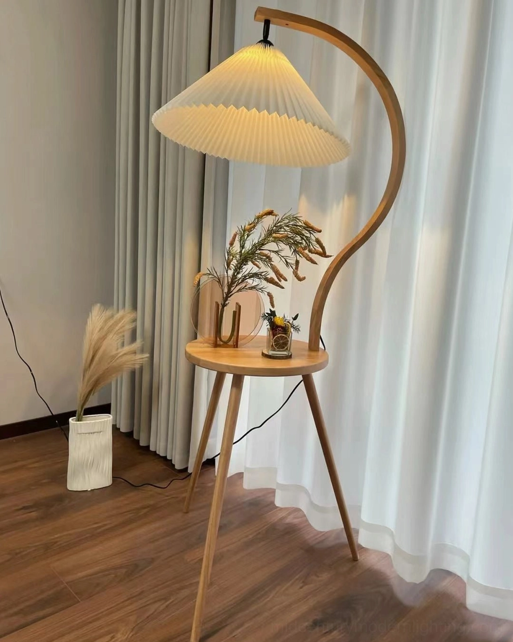 Caprani floor lamp with curved wooden stand and integrated side table in modern home setting