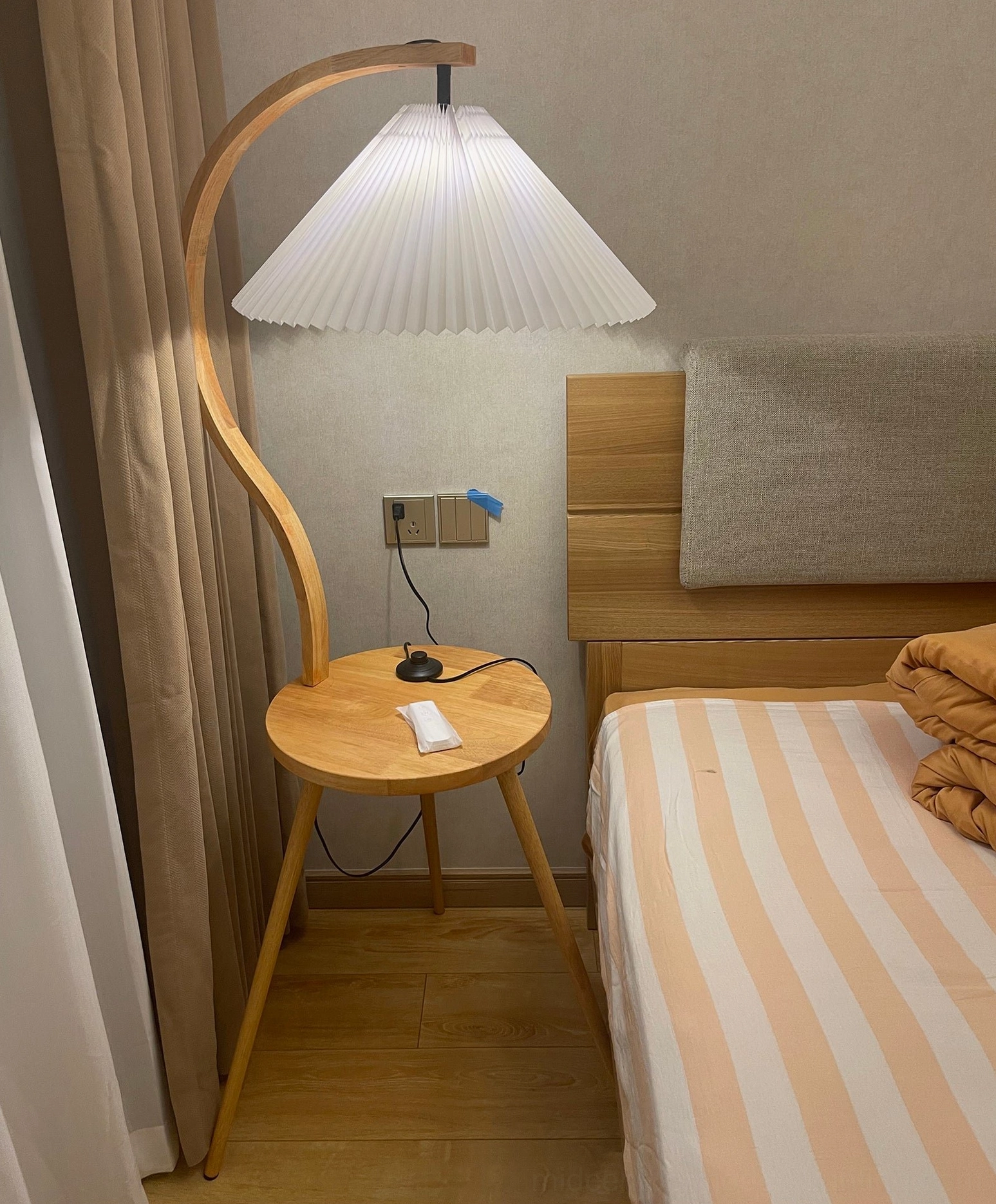 Caprani floor lamp with integrated side table and soft pleated shade in home interior styling