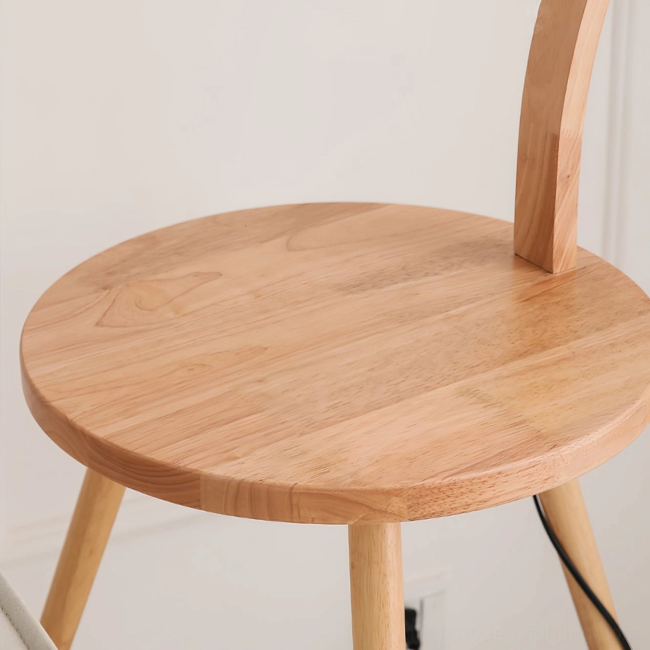 Top-down view of Caprani lamp base, round solid wood tabletop with three natural wood legs