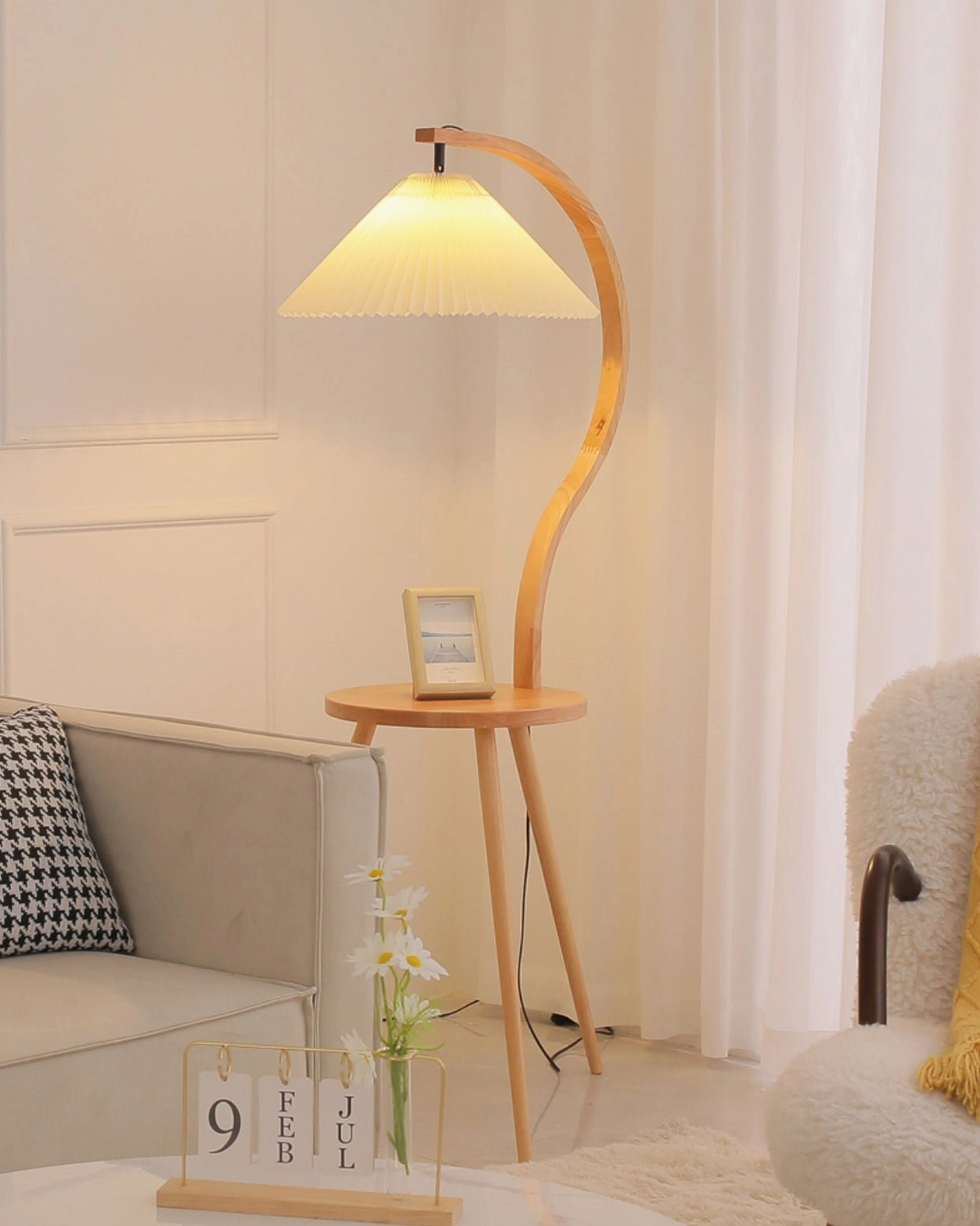 Caprani floor lamp with side table in minimalist living room corner, tabletop with photo frame and accent furniture
