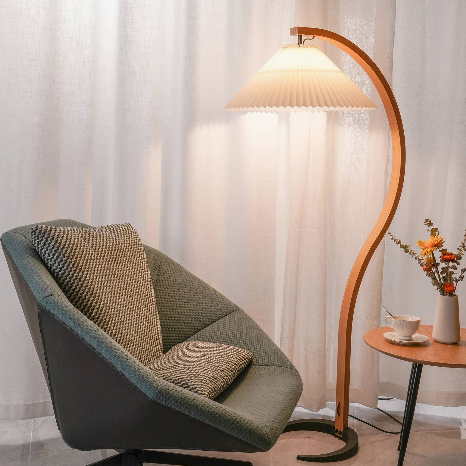 Caprani floor lamp illuminated in bright space with sheer window curtains, warm ambient lighting