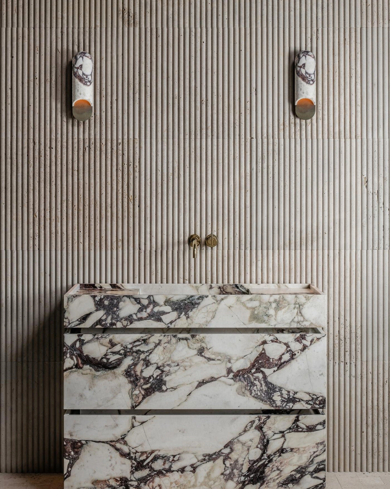 Dual capsule wall lamps flanking bathroom mirror in modern minimalist marble bathroom interior