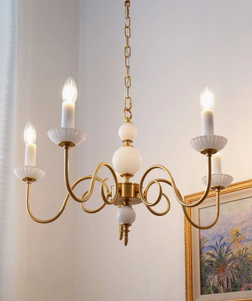 Carlita 4-light brass chandelier hanging illuminated with candle bulbs in classic vintage style