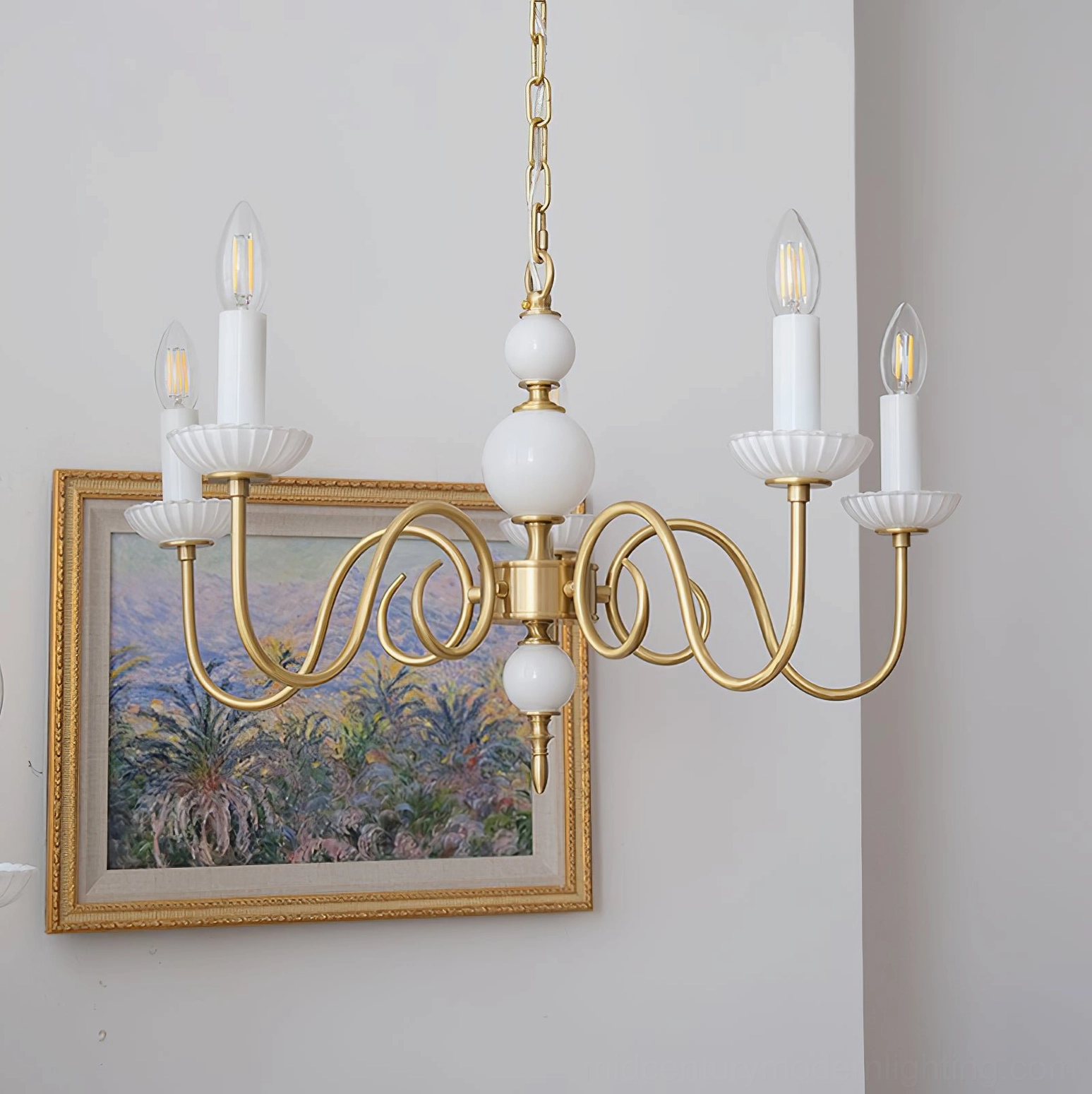 Carlita 5-light brass chandelier side view hanging in interior with landscape art and white ceramics
