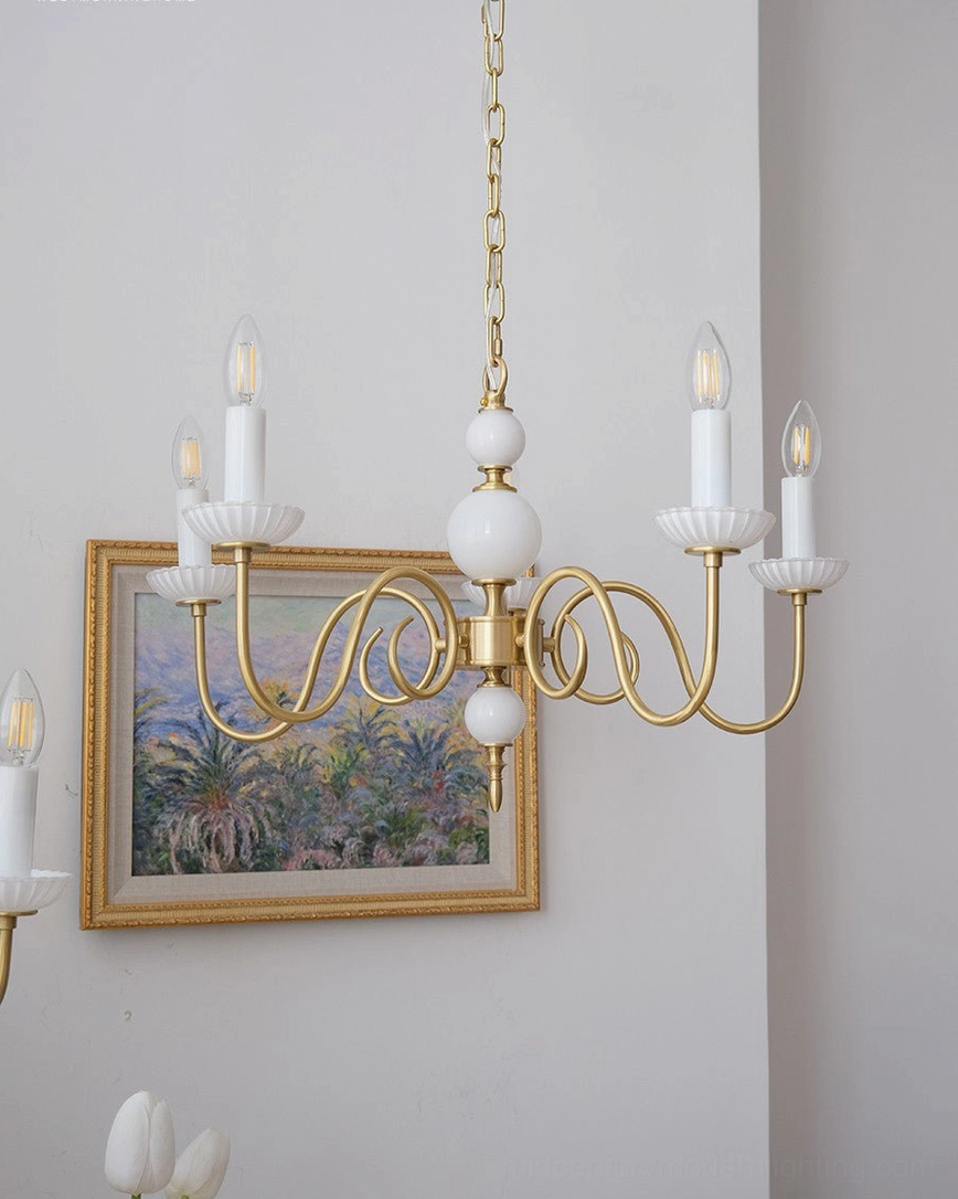 Carlita brass chandelier installed in modern home interior with decorative accents