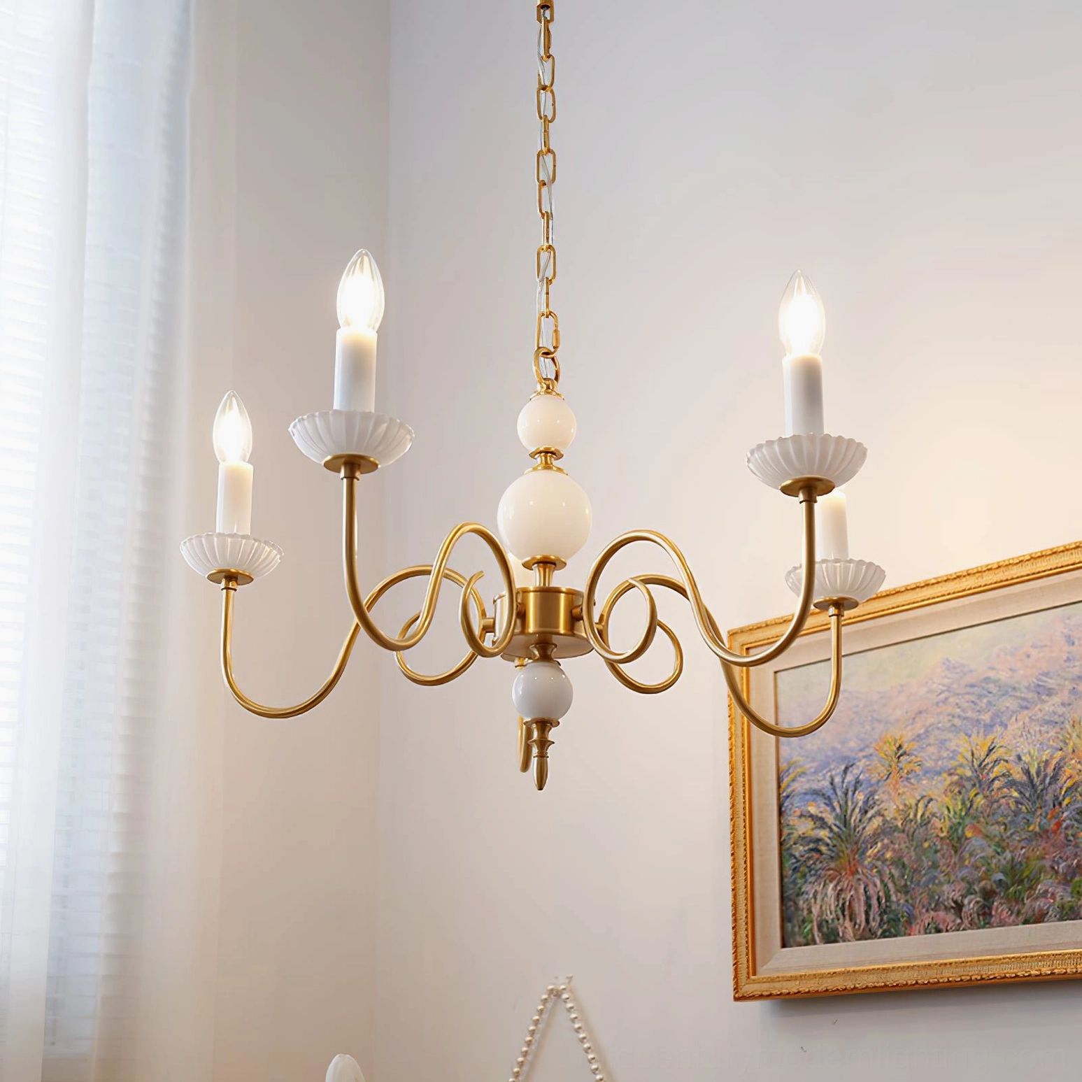 Carlita brass chandelier installed above dining table in elegant home setting