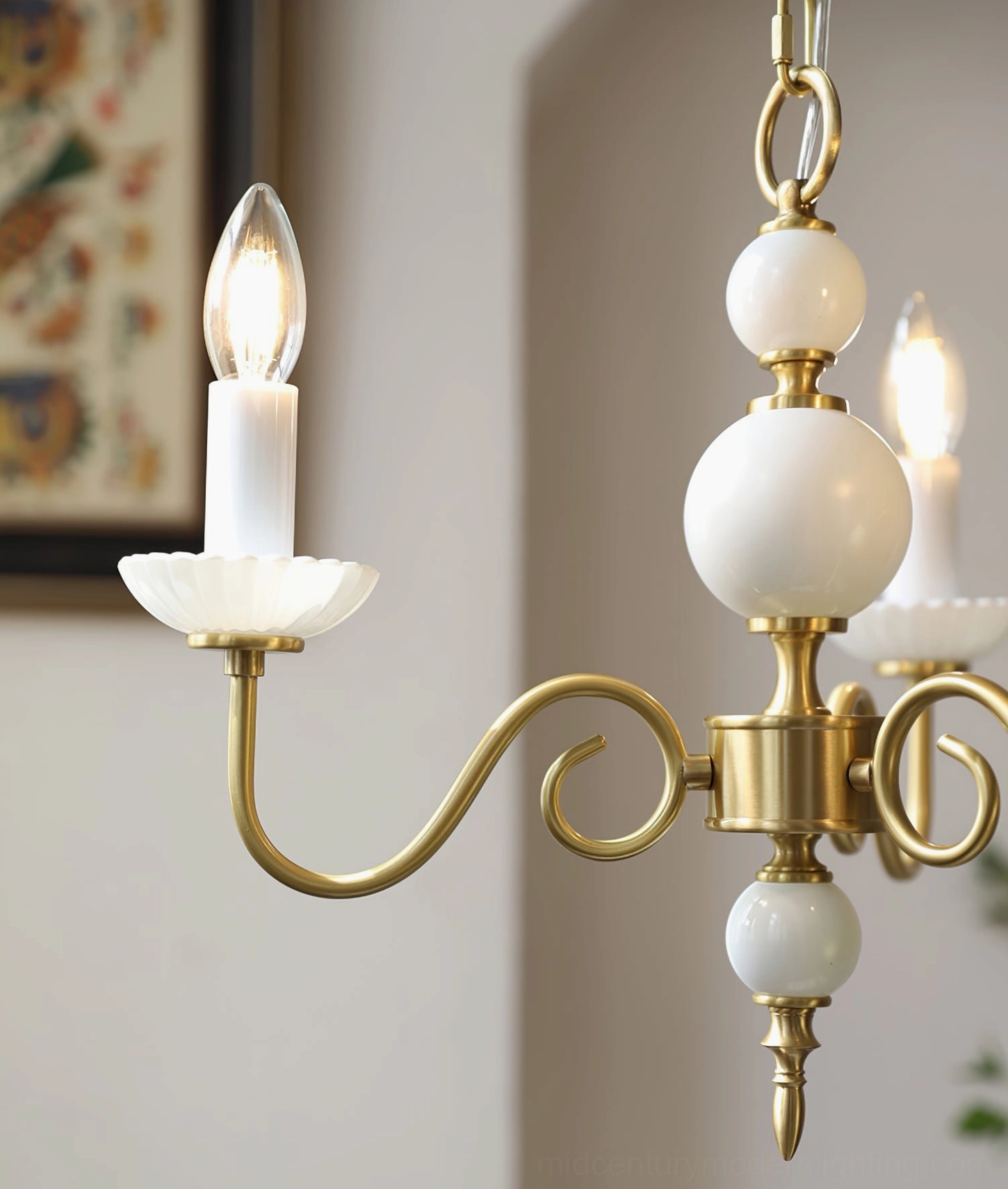 Carlita brass chandelier showing warm glowing bulbs and scalloped lamp tray design