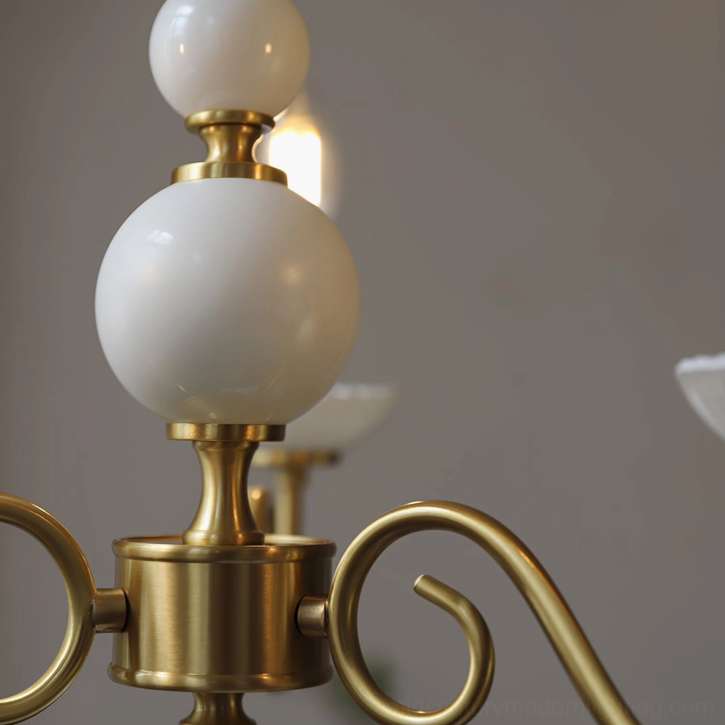 Carlita chandelier hardware close-up showing polished brass and smooth white ceramic spheres