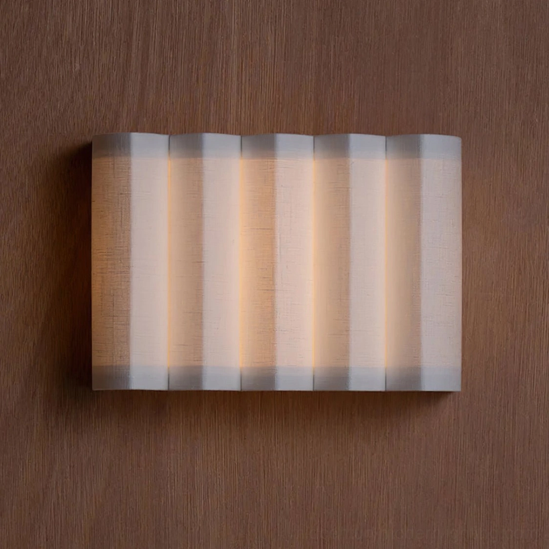 Glowing front-facing linen wall sconce with warm backlight on dark brown wood background