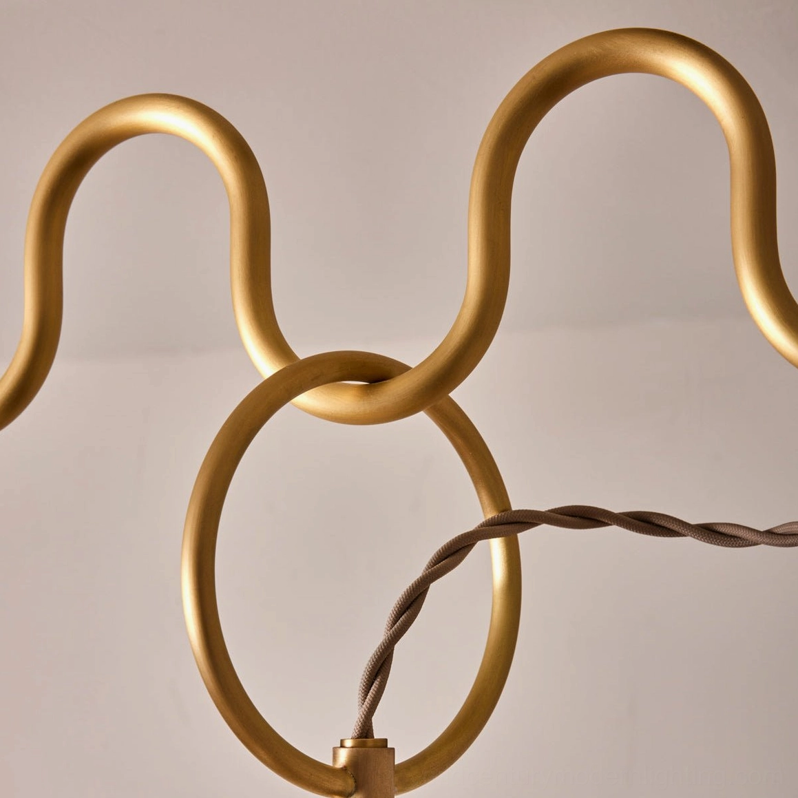 Wavy brass tubing and linked ring joint detail of Cecil chandelier frame with twisted suspension cord