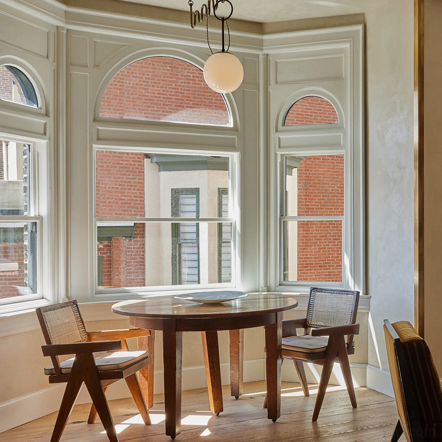 Single-head Cecil pendant light in vintage bay window dining nook with arched traditional windows