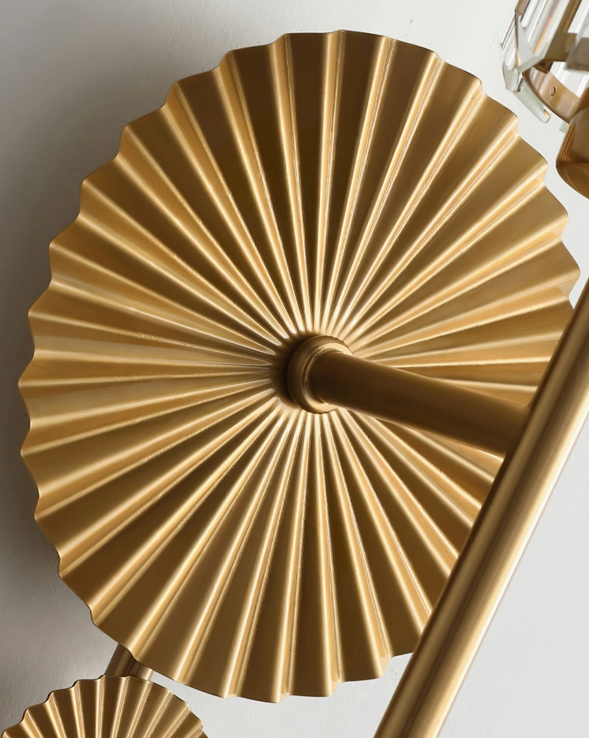 Close-up overhead view of Cecily brass mounting base with sunburst fluted gold texture detail