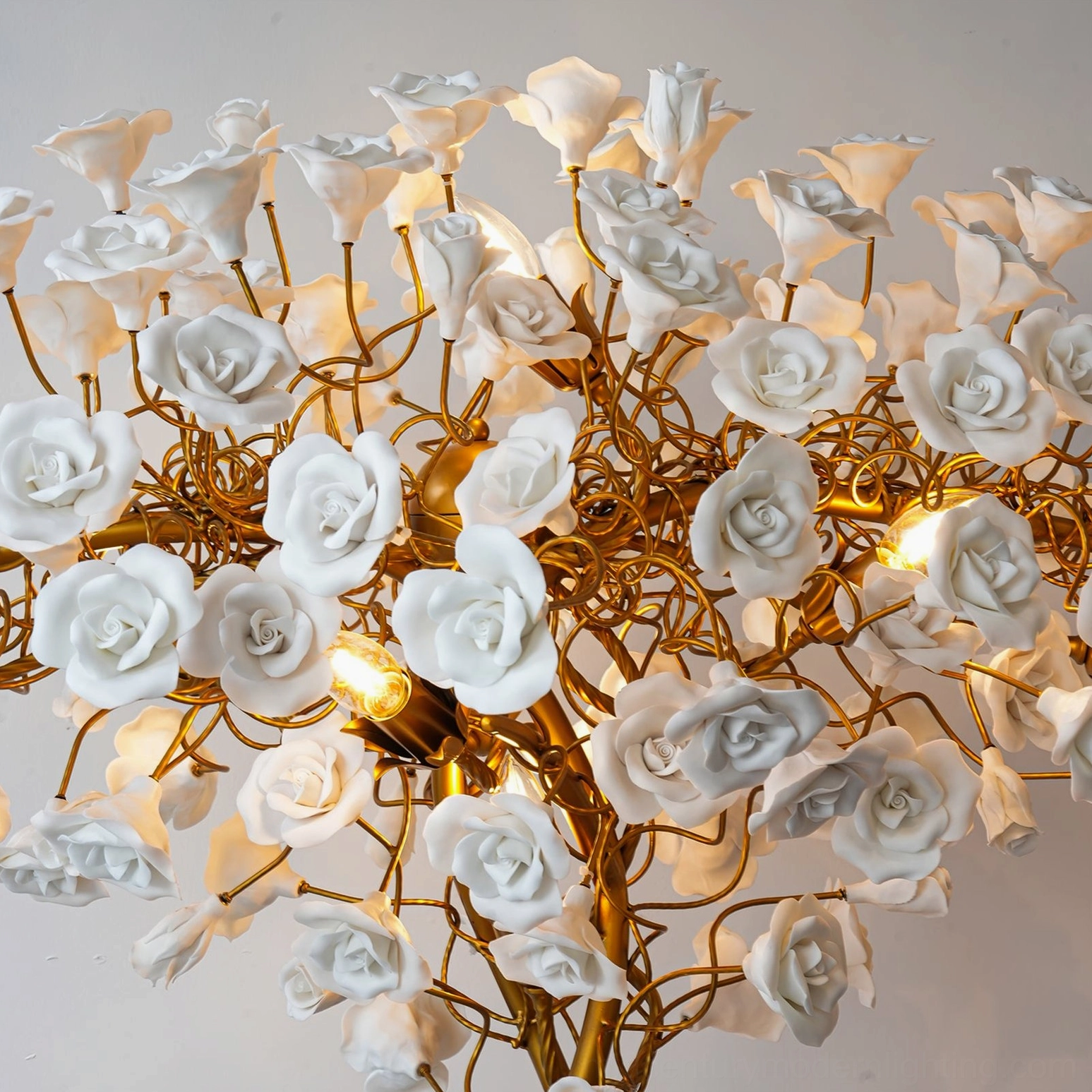 Overhead view of ceramic flower lamp showing twisted brass branches and illuminated white ceramic flowers