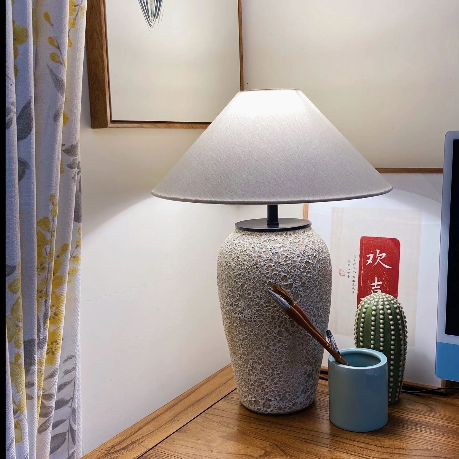 Ceramic table lamp styled on home office desk with cactus plant and minimalist accessories