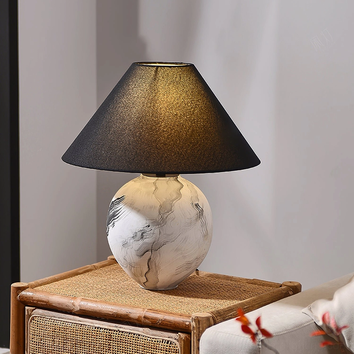Hand-painted ceramic base table lamp displayed on rattan side table in contemporary interior setting