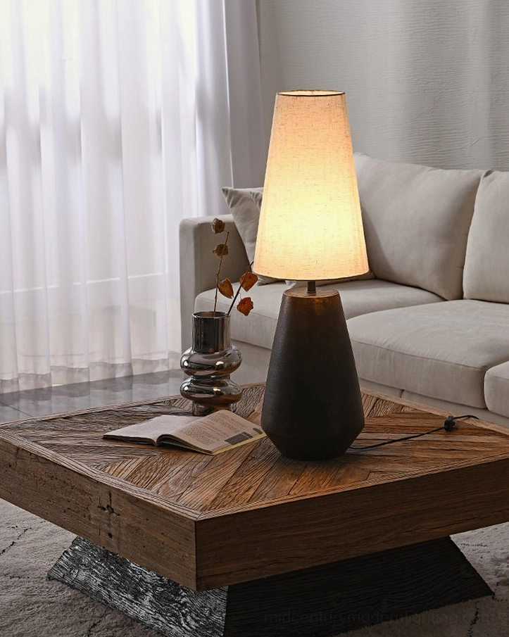 Mid-century modern ceramic table lamp on marble-base coffee table with light gray sofa and natural sunlight in living room