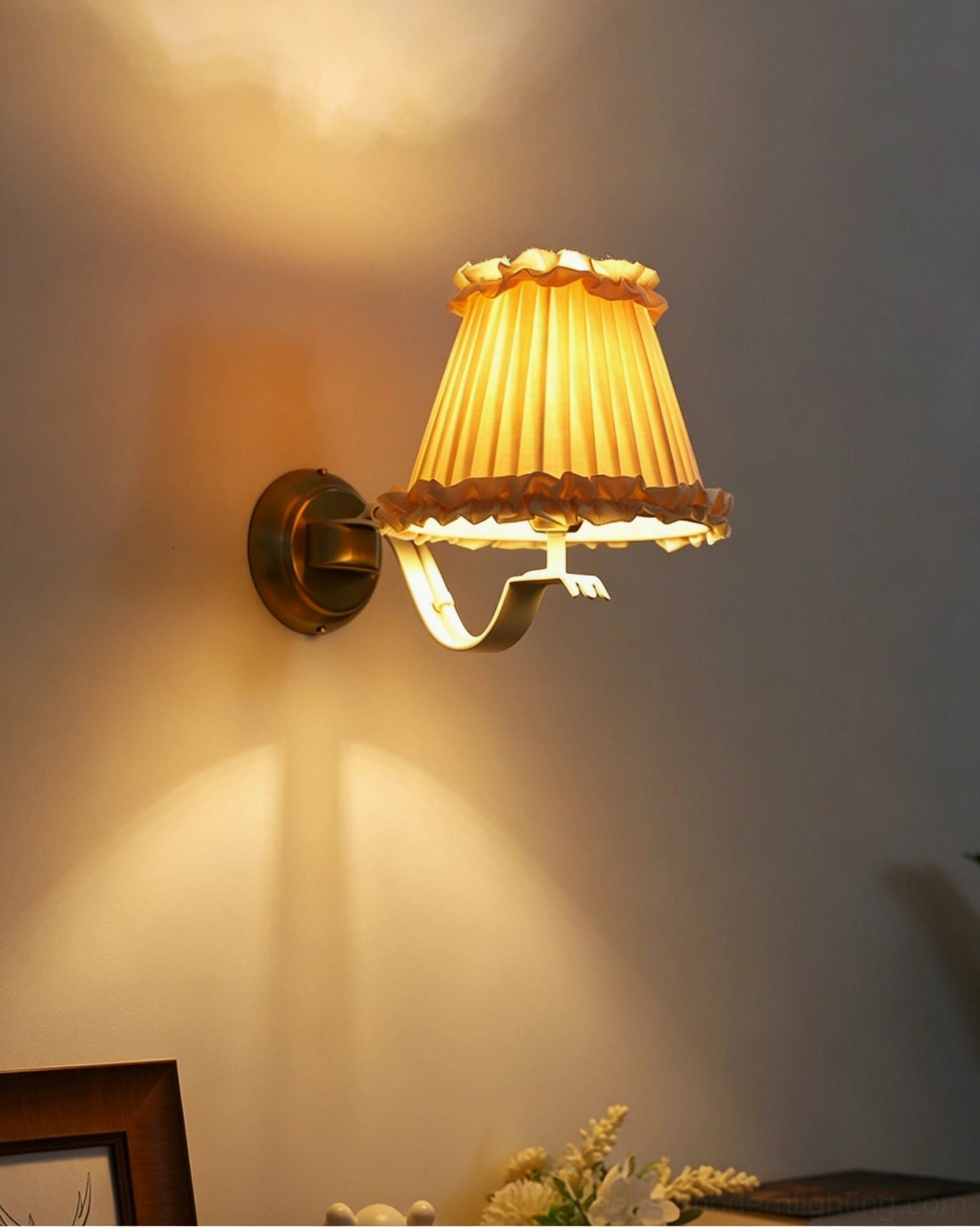 Lit Chantal wall sconce emitting warm yellow light creating focused glow on residential interior wall
