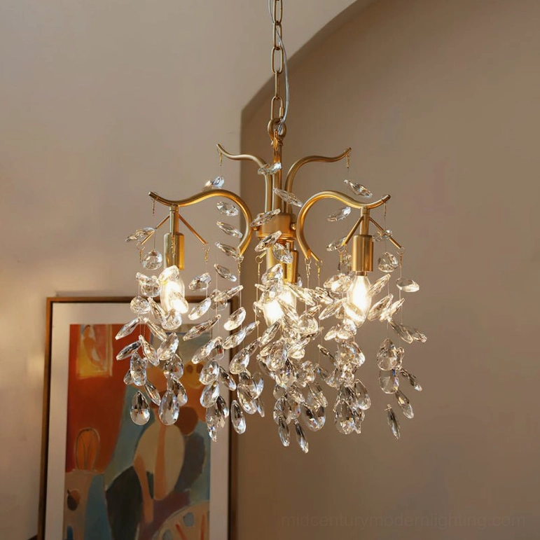Brass crystal leaf chandelier lit with vintage Edison bulbs and faceted crystal clusters, three-quarter front view with contemporary wall art