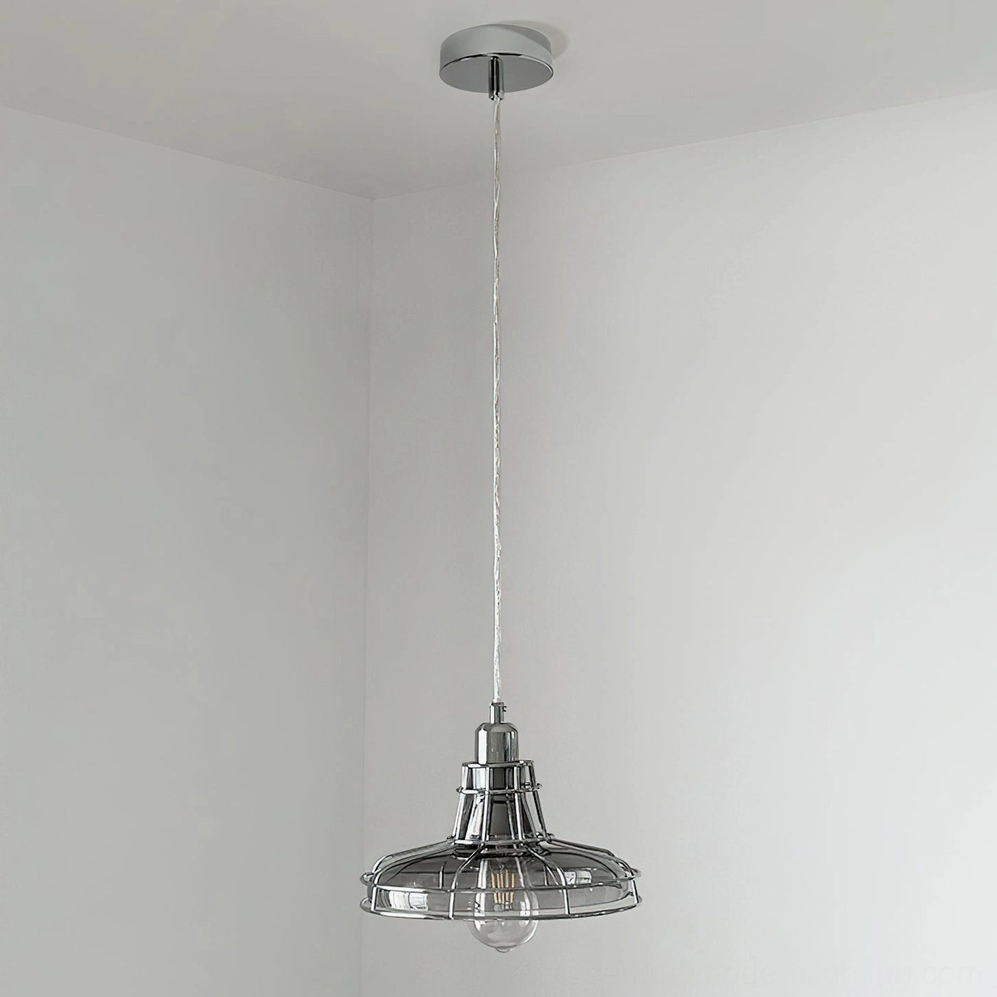 Chrome industrial pendant light with metal cage and unlit bulb, overhead hanging view in minimal modern room