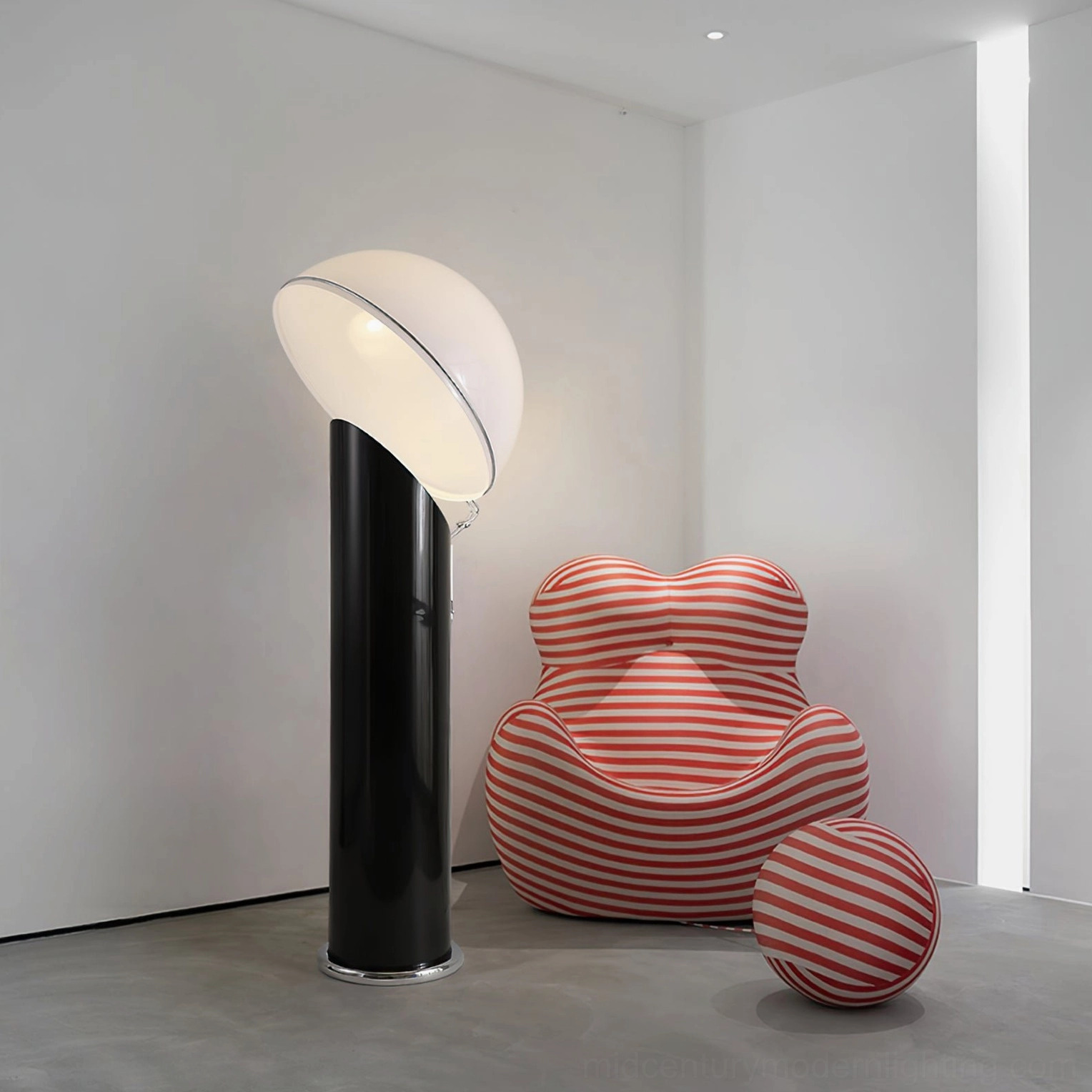 Ciot floor lamp lit in minimalist room with striped accent chair, black pole and curved white dome