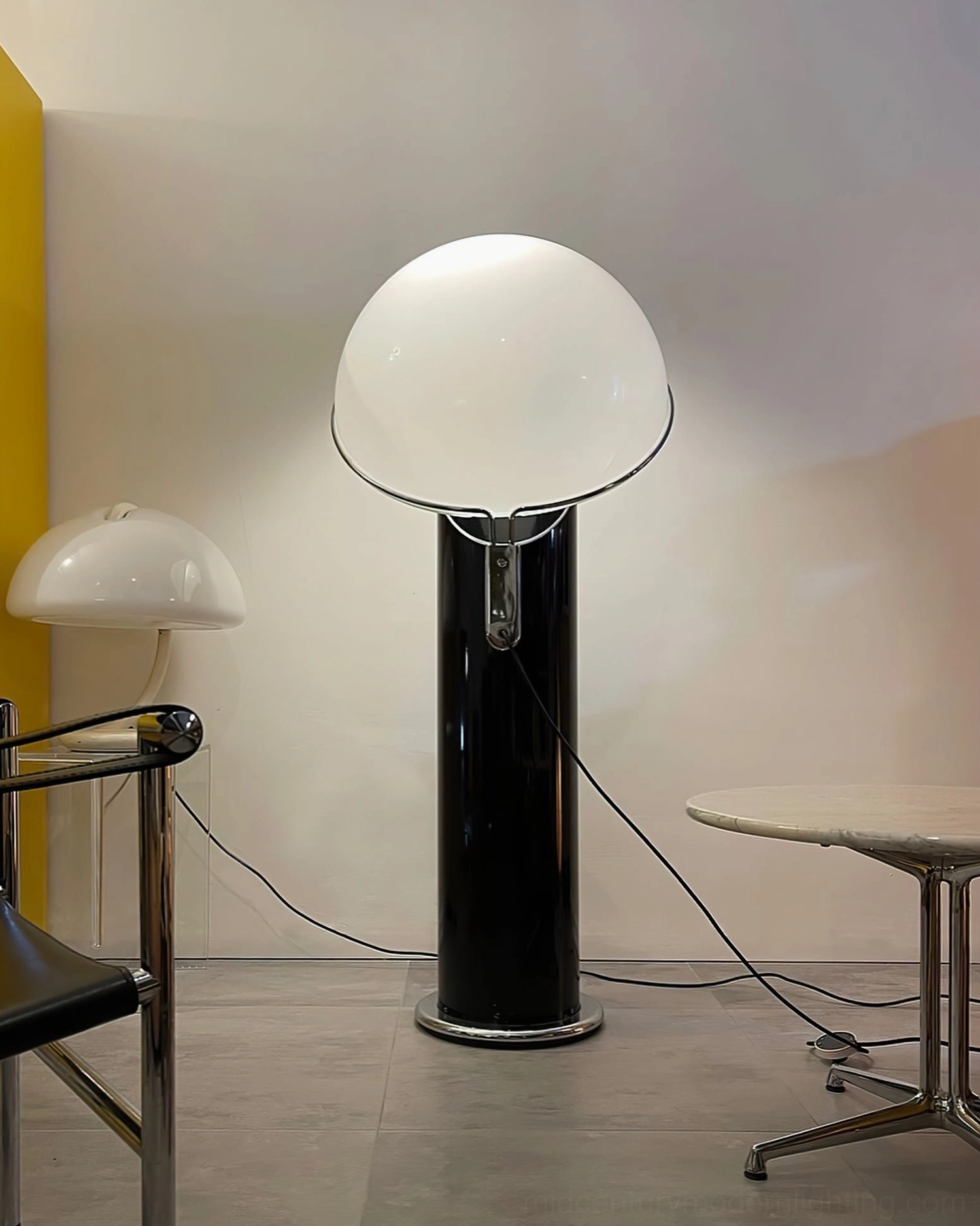 Ciot floor lamp side view showing tall black pole and angled white acrylic dome shade design