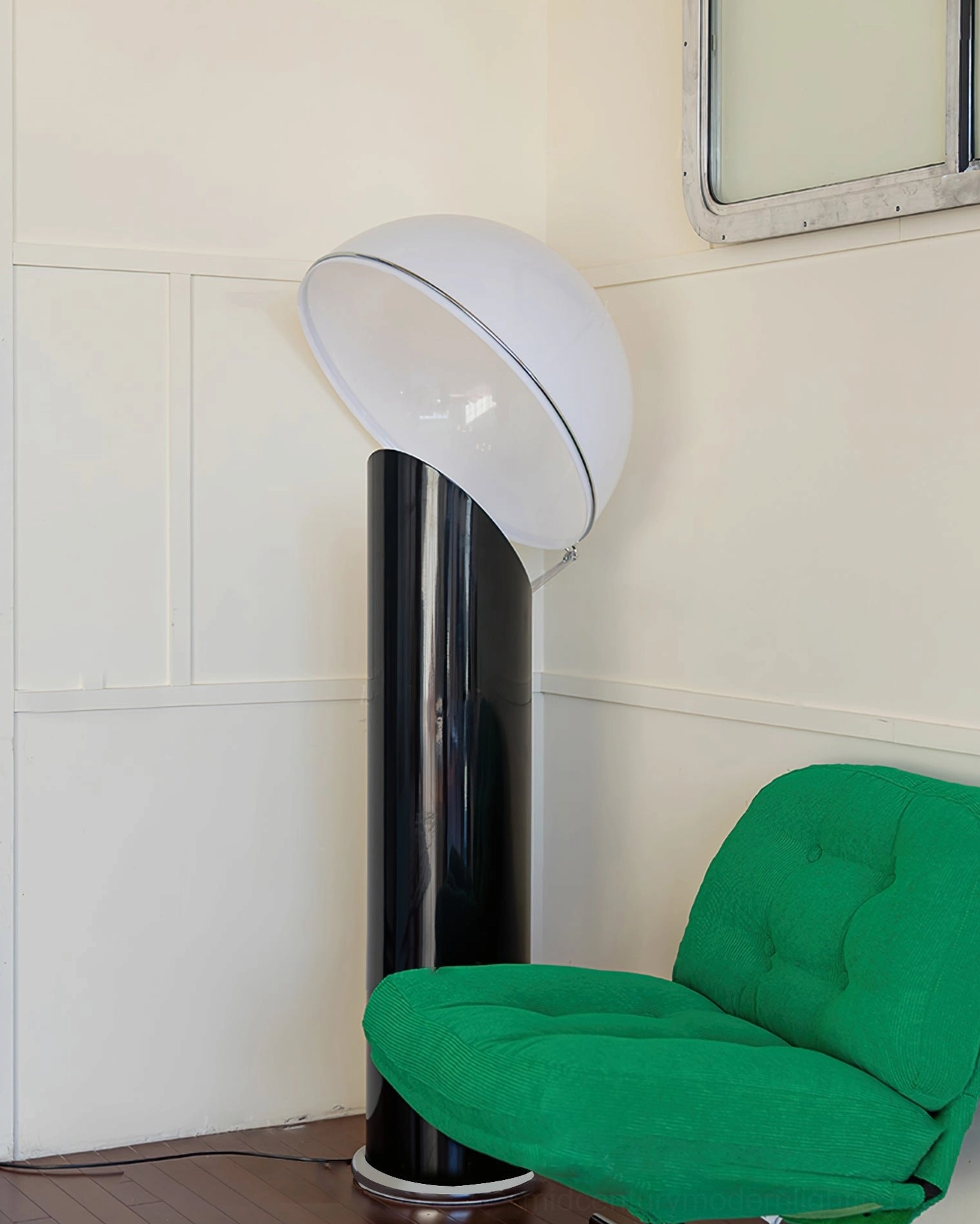 Ciot sculptural floor lamp side angle showing curved white dome and tall black pole near green chair