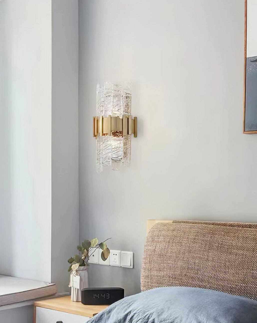 Modern wall sconce in brushed gold with clear rippled glass, product showcase