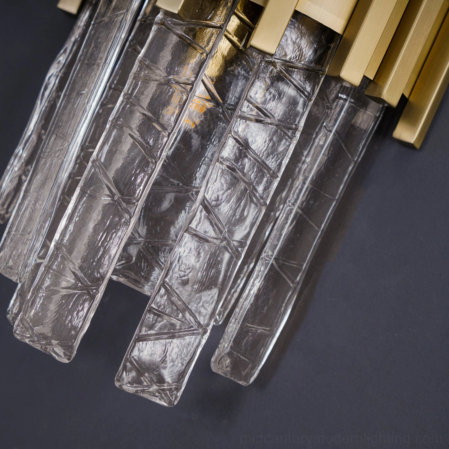 Modern sconce with rippled glass and gold metalwork installed in interior design scheme
