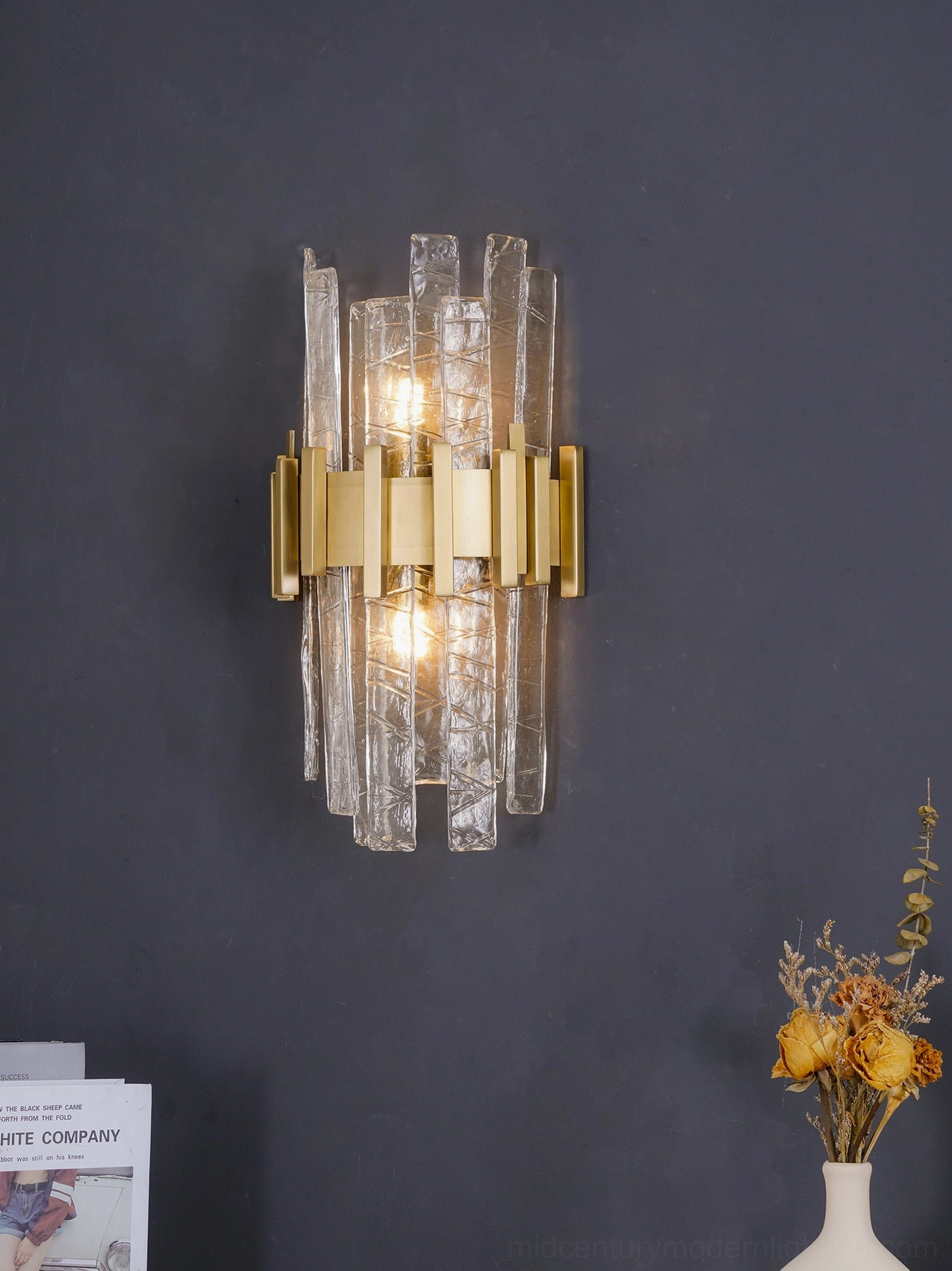Contemporary wall-mounted sconce with gold finish and hand-textured clear glass panels