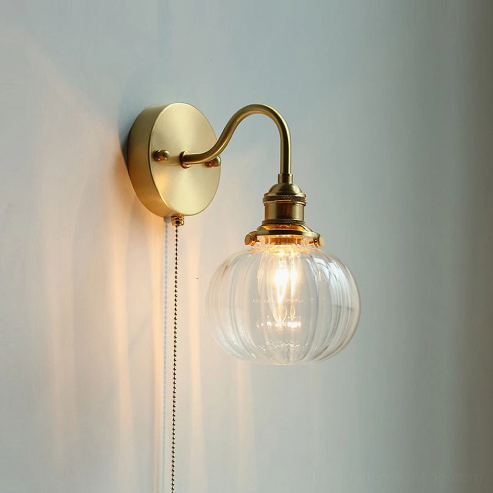 Clear glass brass wall sconce in Scandinavian minimalist design - clean lines mid-century modern