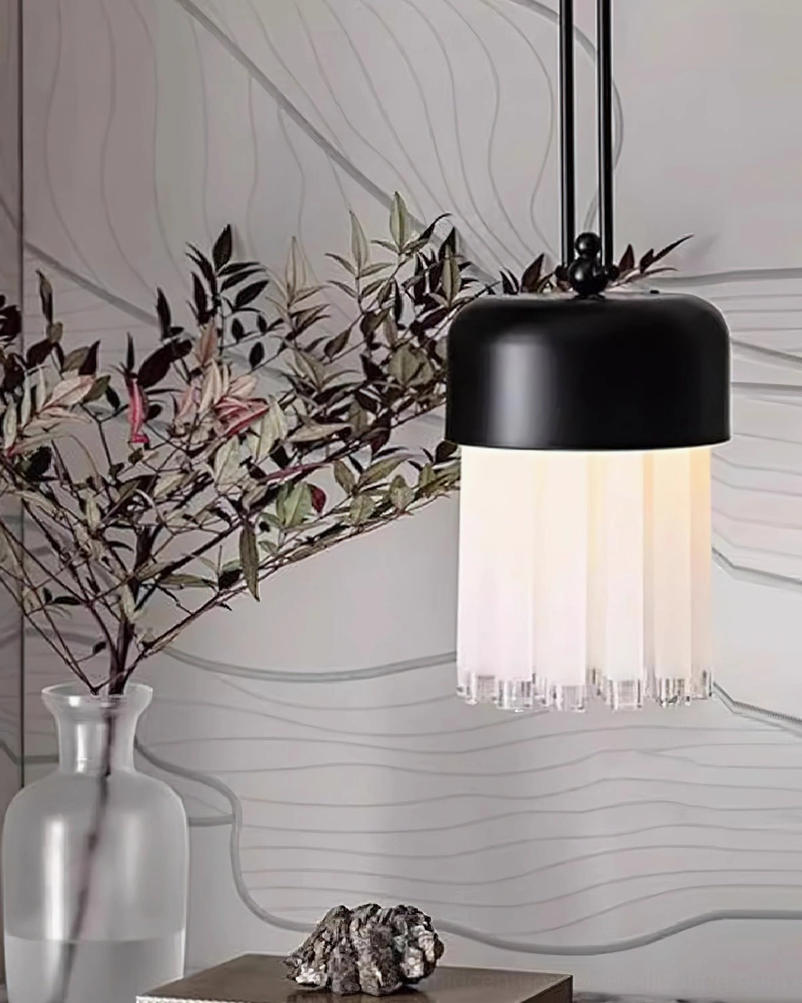 Minimalist pendant fixture close-up, residential corner installation with matte black hardware and decorative floral arrangement