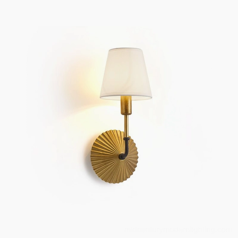 Clove brass wall lamp slight front perspective with warm glowing fabric shade, soft illumination creating ambient light, luxury vintage aesthetic