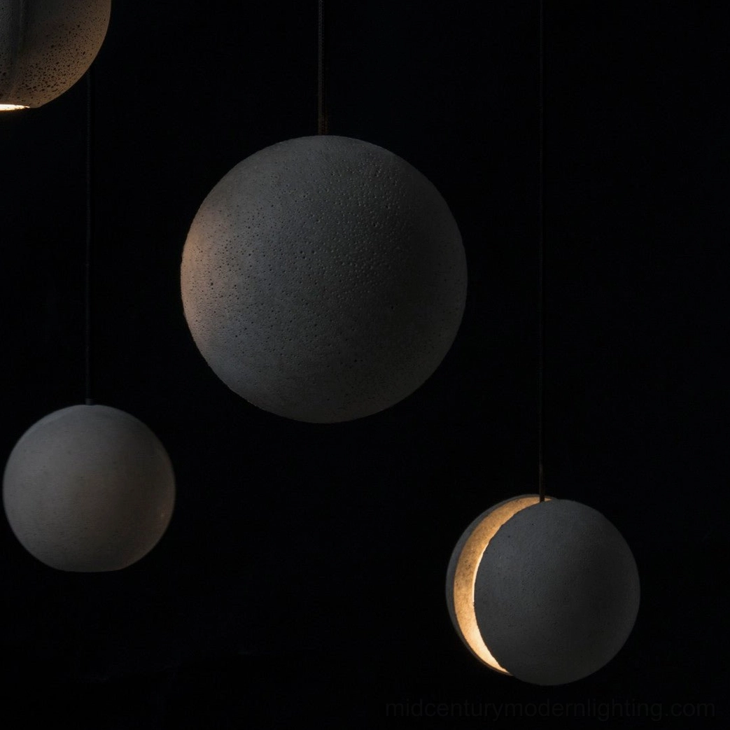 Concrete pendant light with diffused warm illumination from interior gap, artistic lighting effect