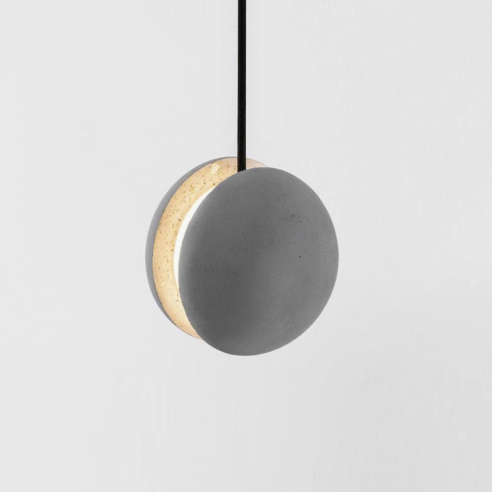 Half-spherical concrete pendant lamp with warm light emitting from curved edge, black hanging cord on white background