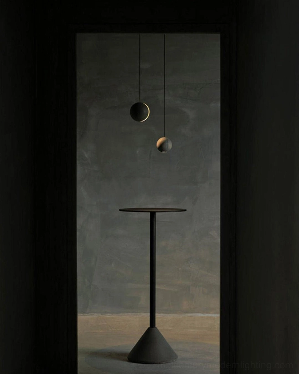 Concrete pendant lamps installed in minimalist dark interior space with small side table, warm ambient lighting