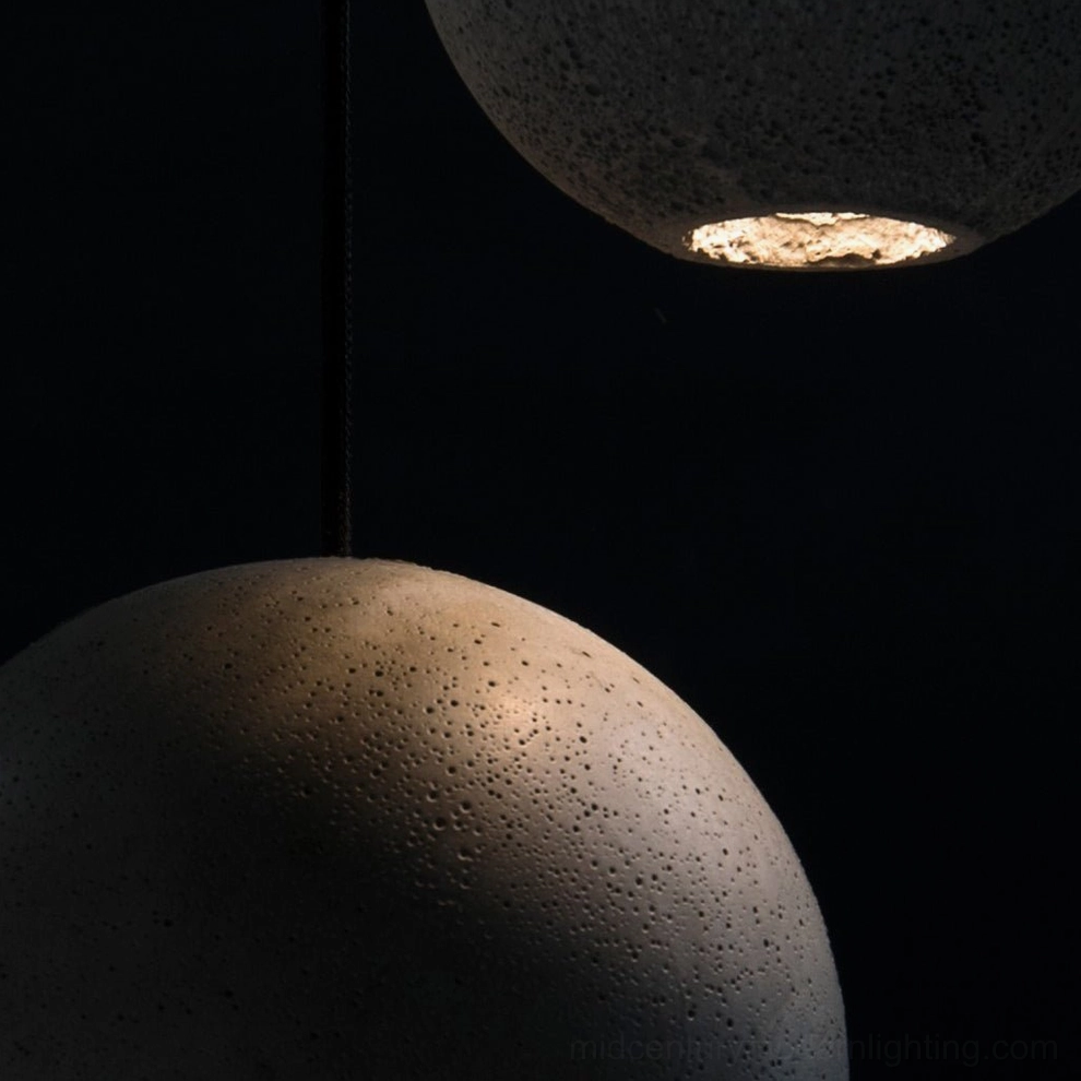 Multiple concrete pendant lamps arranged showing size comparison between different models and designs