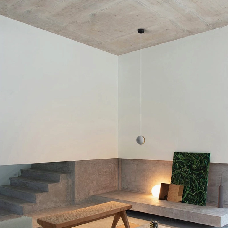Multiple concrete pendant lights creating layered lighting design in modern interior setting