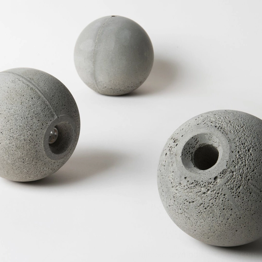 Concrete decorative spheres in overhead flat lay arrangement, showing varied hollow and solid designs with porous texture