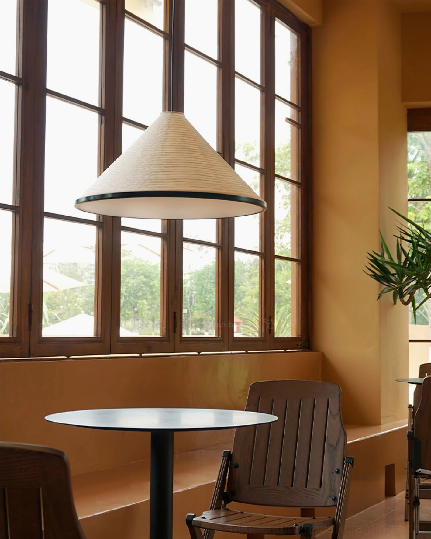 Black trimmed Cone Washi Pendant Light in modern cafe space with low side angle view showing suspension rod